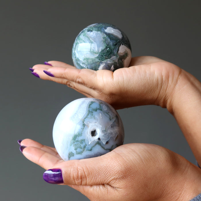 moss agate spheres in hands