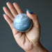 light green moss agate sphere in hand