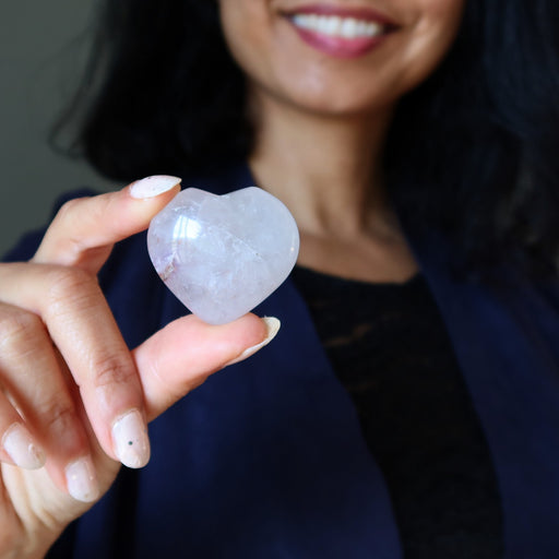 Person holding a heart-shaped amethyst crystal