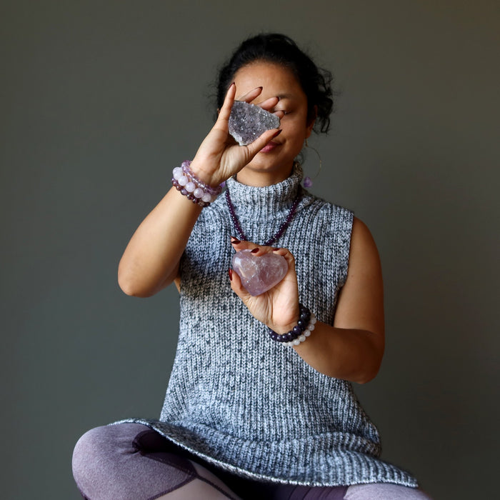 woman meditating with amethyst crystals