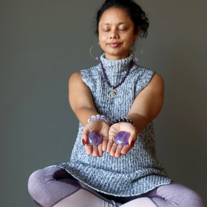 woman meditating with amethyst crystals