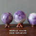 light purple amethyst spheres on display stands
