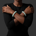 Person wearing two light aquamarine beaded bracelets on a dark background