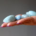 blue aquamarine tumbled stones in hand