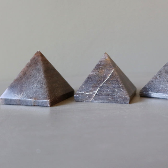 three gray stormy aventurine pyramids