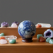 Decorative display of crystal balls and stones on a wooden surface with a gray background