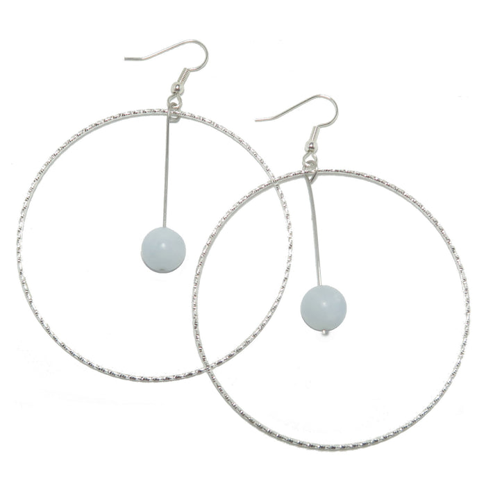 A pair of silver-finished steel hoop earrings with blue calcite gemstones.