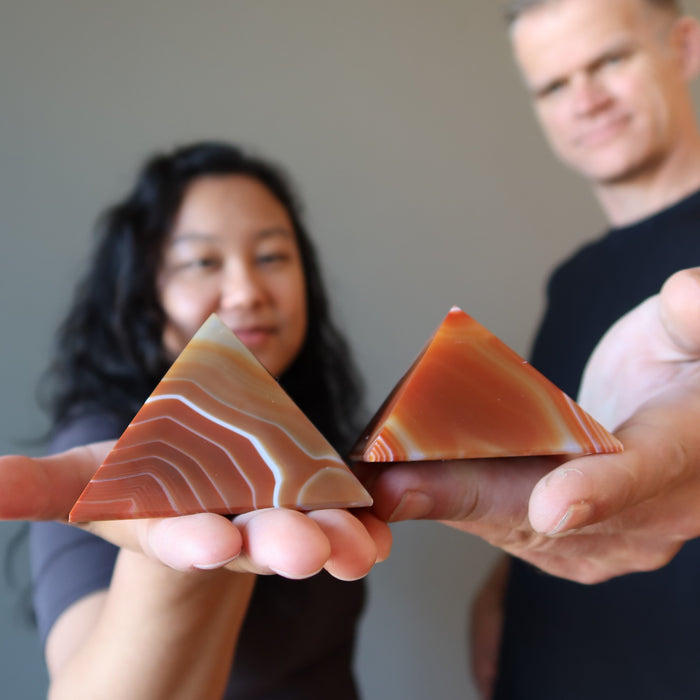 models holding carnelian pyramids