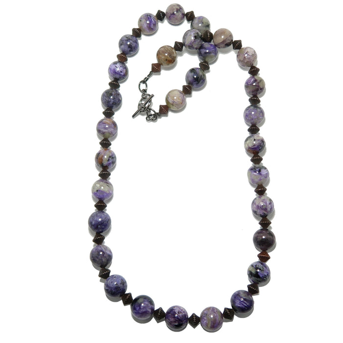 Necklace with purple and brown charoite beads on a white background