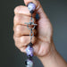 Hand holding a beaded charoite necklace