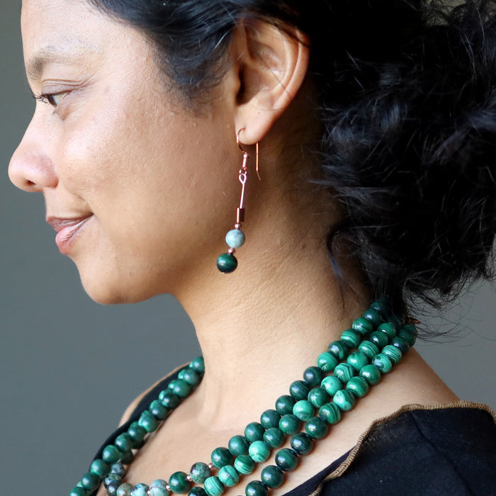 woman wearing chrysocolla malachite copper earrings and malachite necklaces