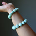 Green Chrysoprase beaded bracelet  on a wrist against a dark background