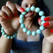 Person holding a Green Chrysoprase beaded bracelet with a blurred background