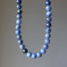 Necklace with blue dumortierite beads on a plain background