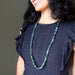model wearing long emerald necklace