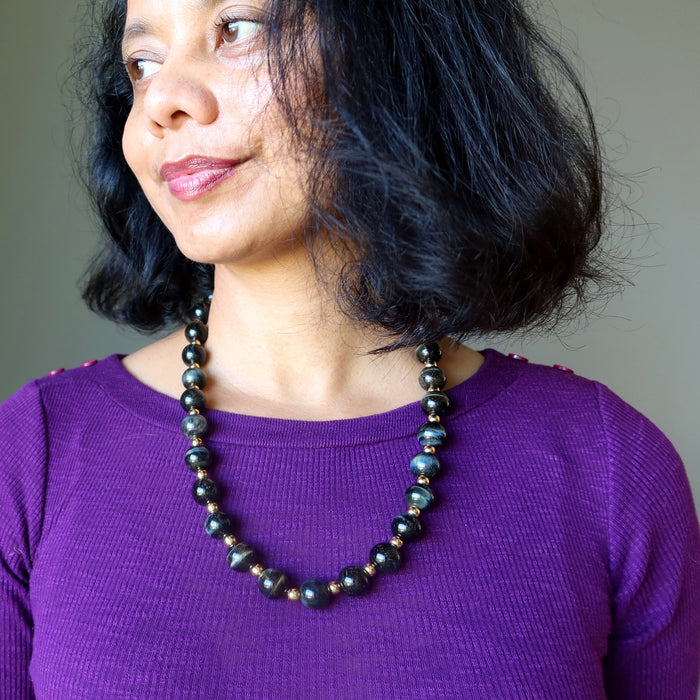 woman wearing hawks eye and gold beaded necklace