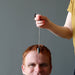 hematite pendulum on man's third eye chakra