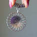Silver Howlite pendant  held by a hand against a gray background