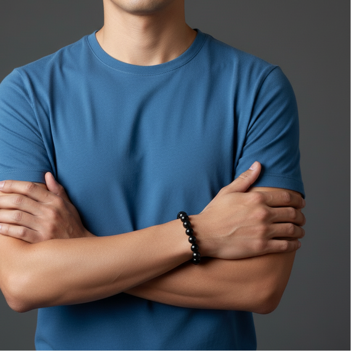 Person wearing a blue t-shirt with arms crossed on a gray background