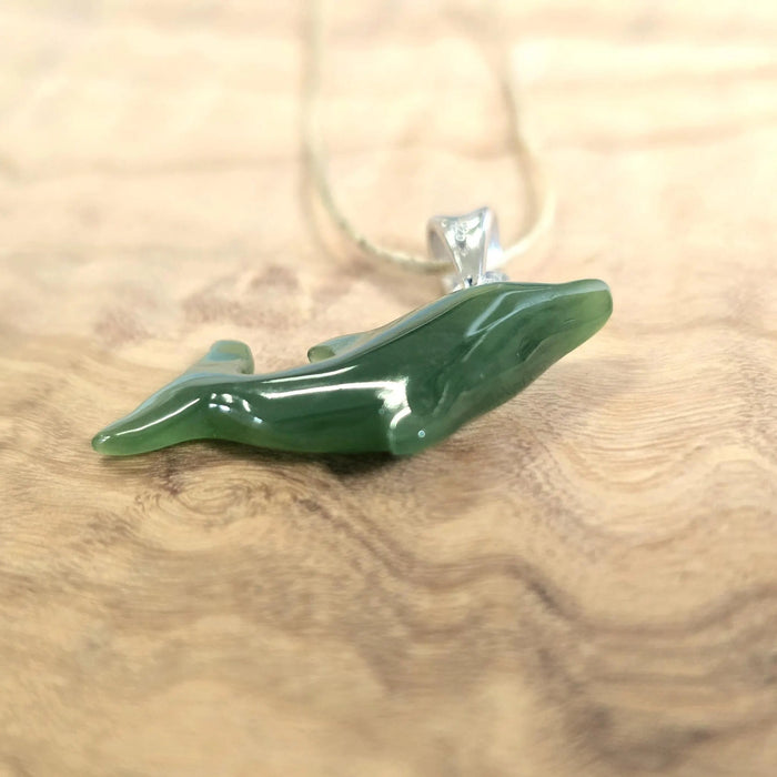 Green jade pendant on a wooden surface