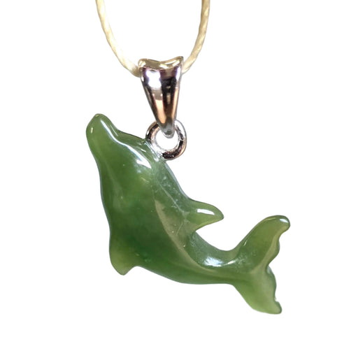 Green dolphin pendant on a gold chain against a blurred background