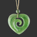 Green jade heart-shaped pendant with spiral design on a white background