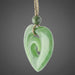 Green jade spiral pendant on a white background