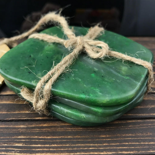 Green jade coasters tied with twine on a wooden surface