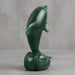 Green jade sculpture of a dolphin on a white background
