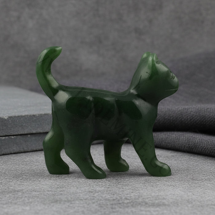 Green jade stone sculpture of a cat on a white background