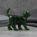 Green jade stone sculpture of a cat on a white background