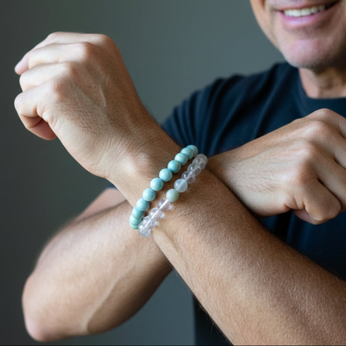 jade and clear quartz bracelets on hands