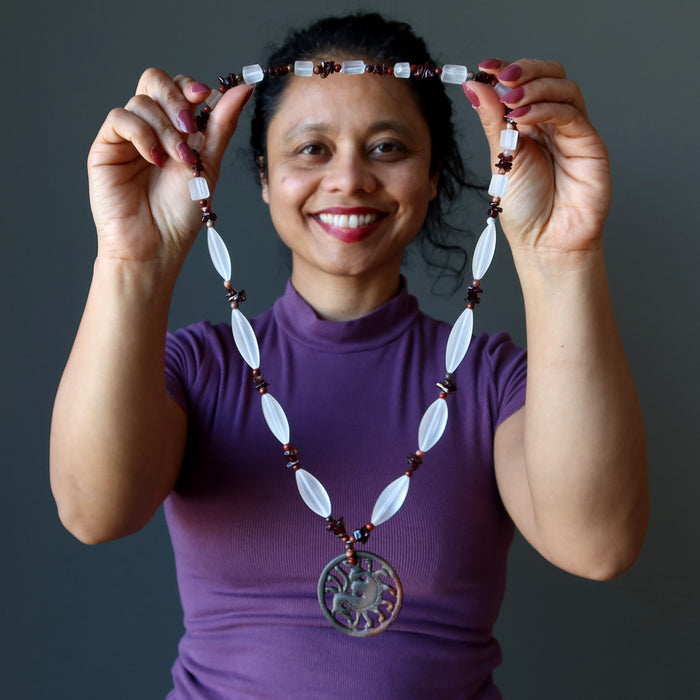 holding Dragon Medallion strung on frosted glass brown jasper and garnet beads necklace