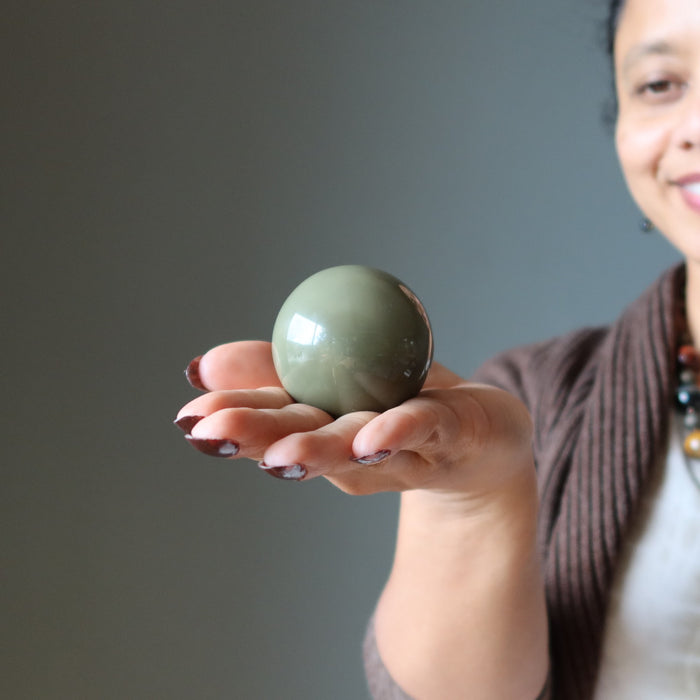 woman holding green jasper sphere