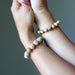 Two wrists wearing beaded Landscape Jasper bracelets against a neutral background
