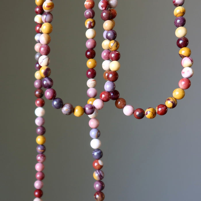 Multicolored mookaite jasper beaded necklace on a gray background