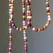 Multicolored mookaite jasper beaded necklace on a gray background