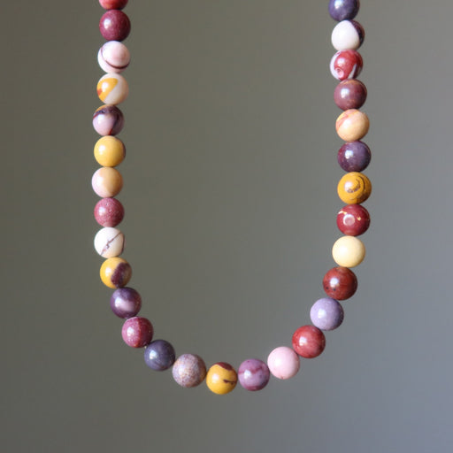 mookaite jasper beaded necklace with multicolored beads on a gray background