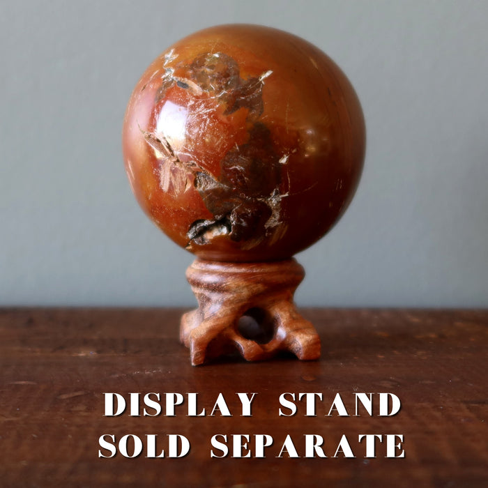 red ocean jasper sphere on wood ball stand