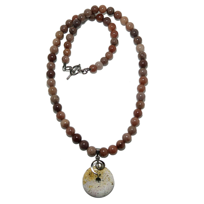 Necklace with purple aventurine beads and a round jasper pendant on a white background