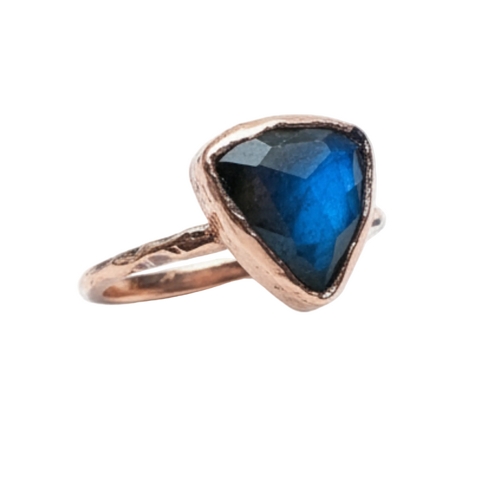 Ring with a blue gemstone and rose gold setting on a white background