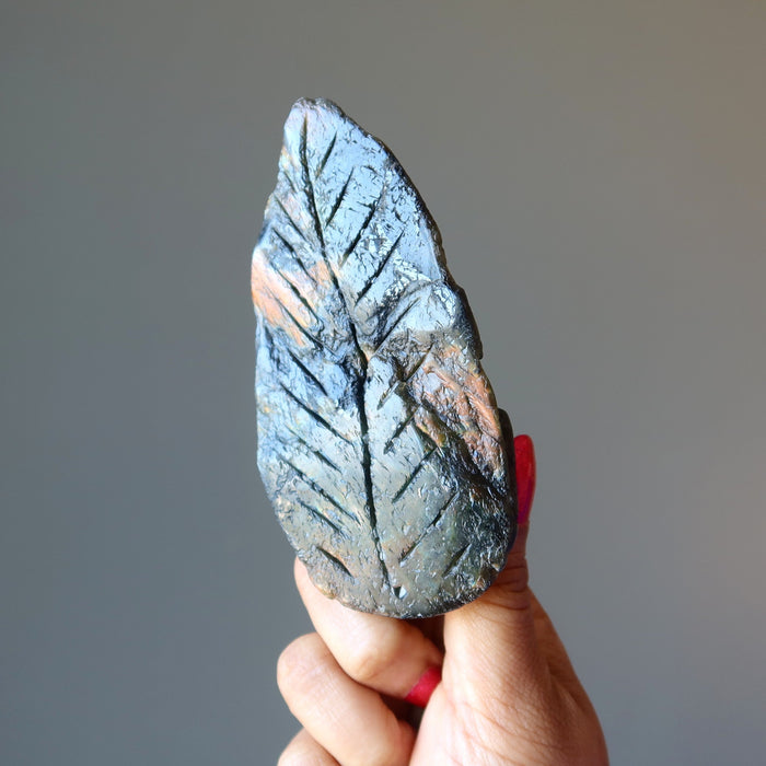 hand holding up a labradorite leaf carving 