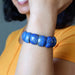 Person wearing a blue Lapis bracelet on a blurred background