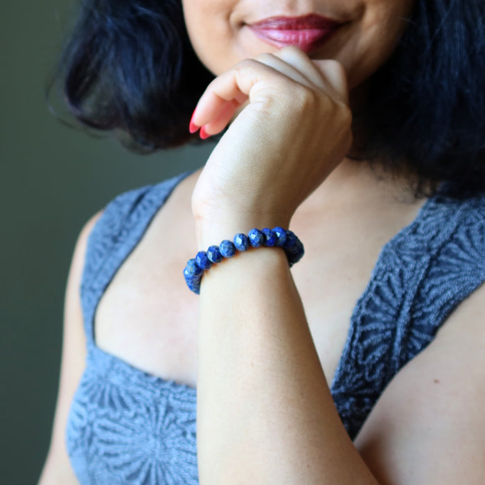 Woman wearing a blue beaded Lapis bracelet on her wrist with a blurred background