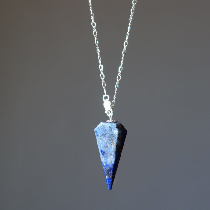 Blue lapis crystal pendant necklace on a gray background