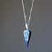 Blue lapis crystal pendant necklace on a gray background