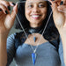 Person holding a lapis silver necklace with a blue pendant
