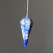 Blue and gray crystal lapis pendulum on a chain against a dark background