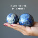two denim lapis spheres in hand