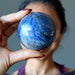 denim lapis sphere in front of face